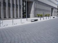 a sidewalk with benches on top of it next to buildings and a bicycle racket