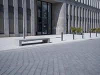 a sidewalk with benches on top of it next to buildings and a bicycle racket