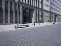 a sidewalk with benches on top of it next to buildings and a bicycle racket