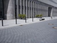 a sidewalk with benches on top of it next to buildings and a bicycle racket