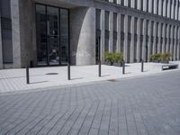 a sidewalk with benches on top of it next to buildings and a bicycle racket
