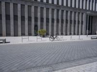 a sidewalk with benches on top of it next to buildings and a bicycle racket
