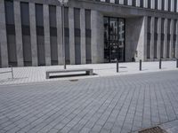 a sidewalk with benches on top of it next to buildings and a bicycle racket