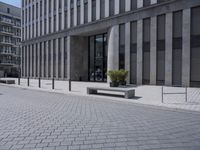a sidewalk with benches on top of it next to buildings and a bicycle racket