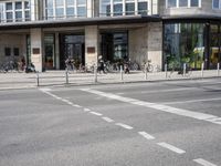 a building with a row of bikes in the front and the street in front that says no entry to bike path