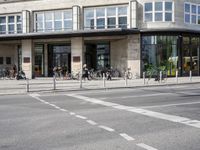 a building with a row of bikes in the front and the street in front that says no entry to bike path