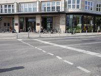 a building with a row of bikes in the front and the street in front that says no entry to bike path