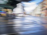 motion blur photograph of street and buildings, including road and pedestrian crossing, in an urban area