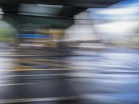 motion blur photograph of street and buildings, including road and pedestrian crossing, in an urban area