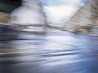 motion blur photograph of street and buildings, including road and pedestrian crossing, in an urban area