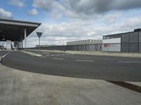 a view of a parking lot, including two buildings and a highway with traffic going down it