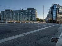 several large glass buildings stand around on a deserted street in a city with a concrete sidewalk that goes over