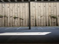 a wall with two trees between two parking spaces, seen from the bottom level of the photo