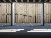 a wall with two trees between two parking spaces, seen from the bottom level of the photo