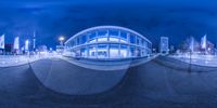 a very blurry photograph of a building near some poles and lights in the foreground