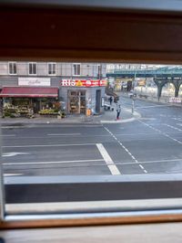 a view out the window of a street scene with traffic and pedestrians on it and a bridge
