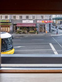 a view out the window of a street scene with traffic and pedestrians on it and a bridge