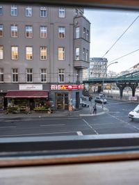 a view out the window of a street scene with traffic and pedestrians on it and a bridge