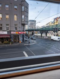 a view out the window of a street scene with traffic and pedestrians on it and a bridge