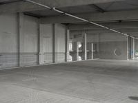 a parking garage with a metal floor and fire hydrant in it that is empty