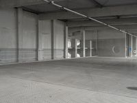 a parking garage with a metal floor and fire hydrant in it that is empty