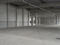 a parking garage with a metal floor and fire hydrant in it that is empty