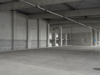 a parking garage with a metal floor and fire hydrant in it that is empty