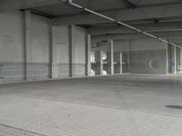 a parking garage with a metal floor and fire hydrant in it that is empty