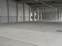 a parking garage with a metal floor and fire hydrant in it that is empty