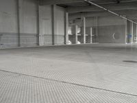 a parking garage with a metal floor and fire hydrant in it that is empty