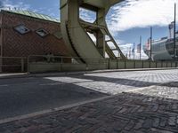 the view looking up from inside an arch at the docks with ships behind it and buildings and the bridge over it