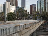 a wide bridge with a lot of tall buildings behind it in a city setting with an overpass