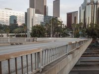 a wide bridge with a lot of tall buildings behind it in a city setting with an overpass