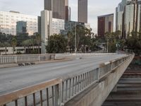 a wide bridge with a lot of tall buildings behind it in a city setting with an overpass