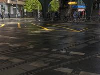 the people are waiting in the wet tracks of an empty street in town during the rain