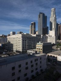 a large white building with lots of windows is standing in the middle of a big city