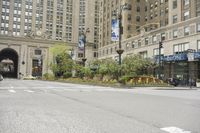 an intersection of cars, street lights and tall buildings in the city of chicago's heart