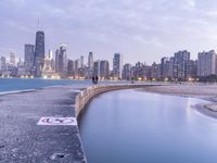 the skyline of chicago with no swimming sign at the edge of a pier at dusk