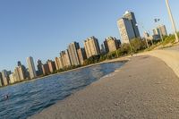 a view of buildings and water, including a few people walking along it near the shore