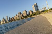 a view of buildings and water, including a few people walking along it near the shore