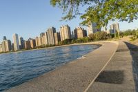 a view of buildings and water, including a few people walking along it near the shore