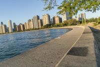 a view of buildings and water, including a few people walking along it near the shore