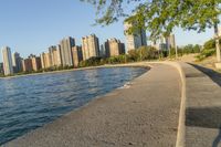 a view of buildings and water, including a few people walking along it near the shore