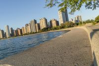 a view of buildings and water, including a few people walking along it near the shore