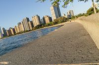 a view of buildings and water, including a few people walking along it near the shore