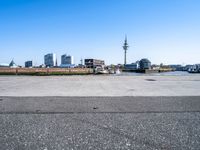 parking lot with truck on side and buildings along it and blue sky with no clouds in background