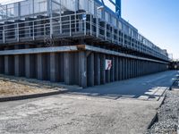 concrete road and walkway by steel rail bridges in city setting in daylight sunlit daytime