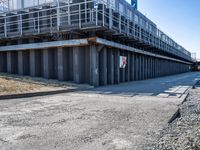 concrete road and walkway by steel rail bridges in city setting in daylight sunlit daytime