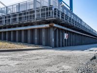 concrete road and walkway by steel rail bridges in city setting in daylight sunlit daytime