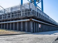 concrete road and walkway by steel rail bridges in city setting in daylight sunlit daytime